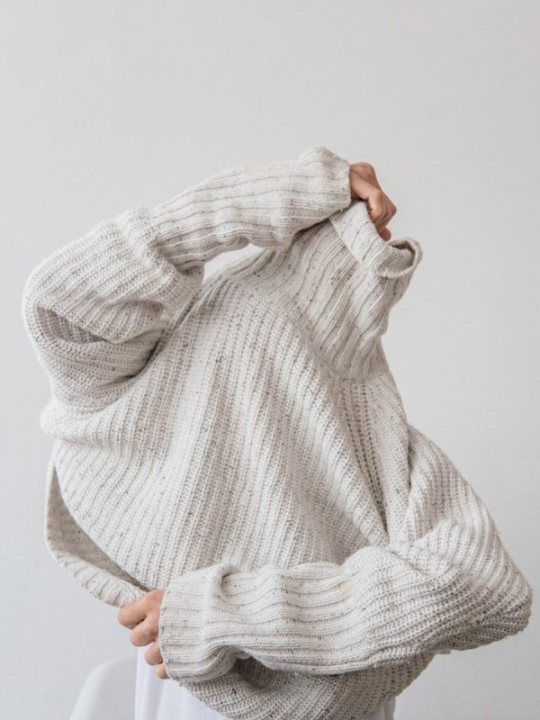 person wearing grey knit sweater